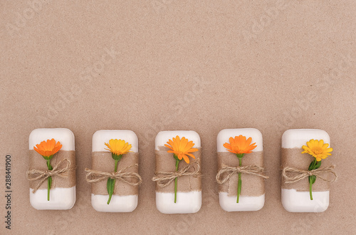 Handmade natural soap set decorated with craft paper, scourge and orange calendula flowers. Organic cosmetics concept. Top view Flat lay Copy space Template for design