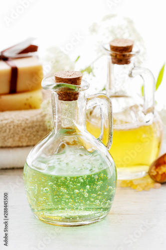 Glass bottles with liquid soap and other spa cosmetics on the table.