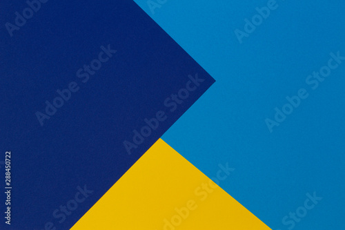 Creative abstract blue and yellow color geometric paper compositon background, top view
