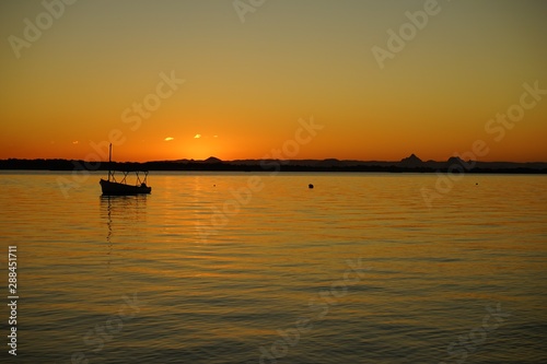 sun setting over calm water © glen