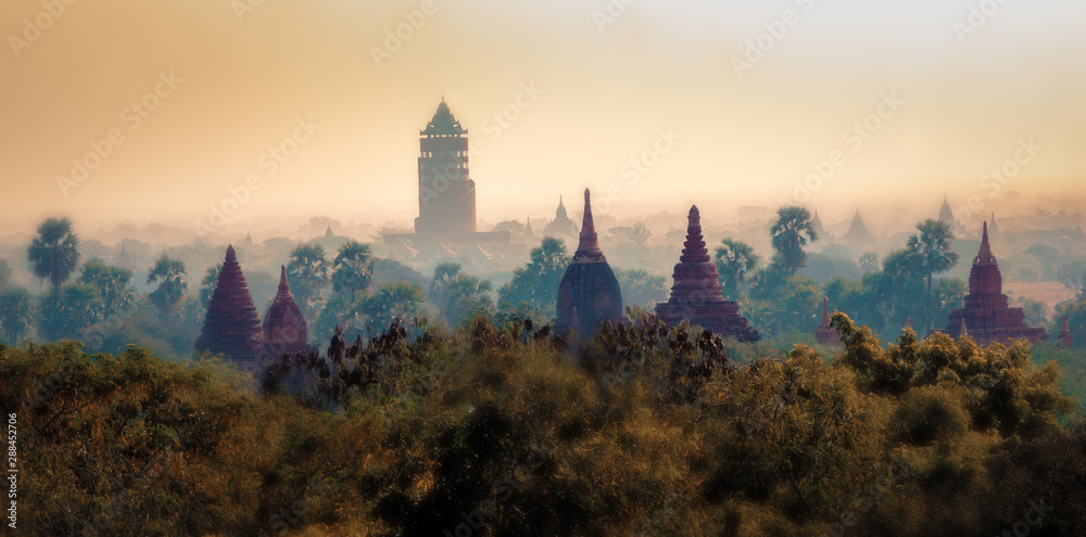 Silhouettes of ancient Buddhist temples in Bagan, Myanmar during sunset. Aerial view. Panoramic landscape