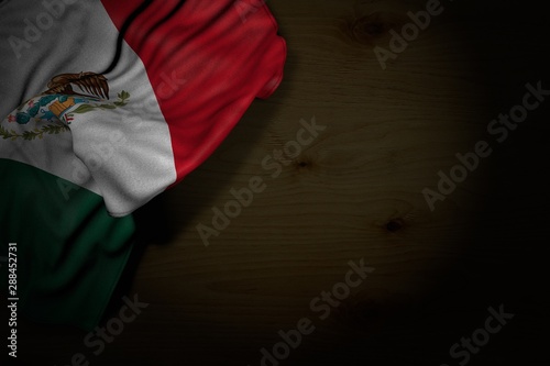 Fototapeta Naklejka Na Ścianę i Meble -  wonderful dark image of Mexico flag with large folds on dark wood with empty space for text - any celebration flag 3d illustration..