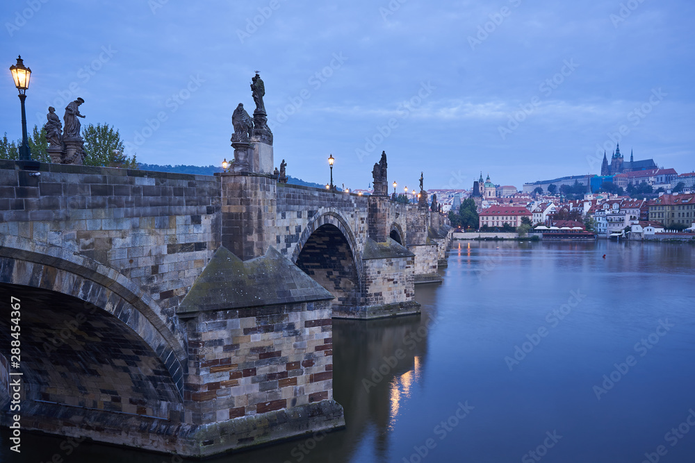 Fototapeta premium Landscape Picture of romantic Charles bridge with Prague castle on other bank of Vltava river in Prague taken in blue hour before sunrise, famous european gothic style architecture in Czech republic.
