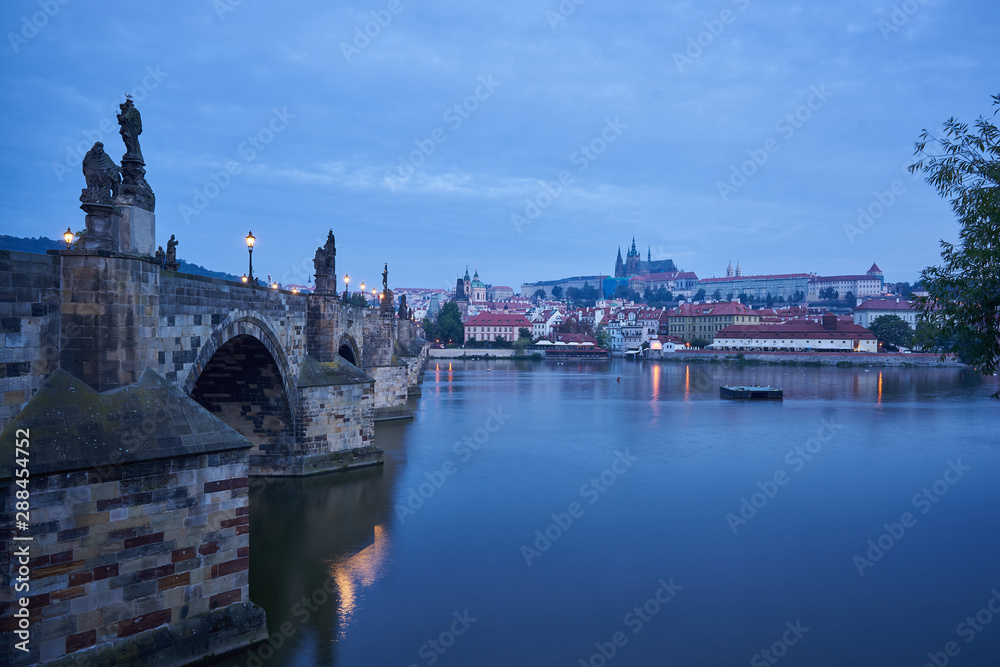 Fototapeta premium Landscape Picture of romantic Charles bridge with Prague castle on other bank of Vltava river in Prague taken in blue hour before sunrise, famous european gothic style architecture in Czech republic.
