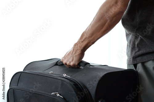 Man hand holding black luggage