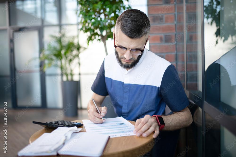 Young businessman analyzing finances and expenses Young businessman analyzing finances and expenses
