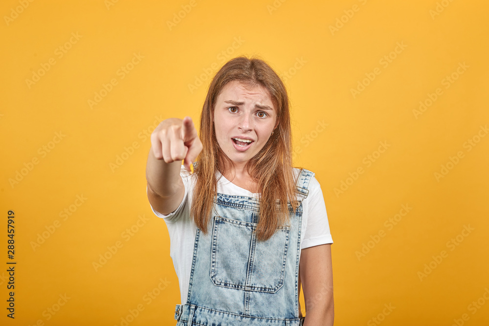 Young woman wearing white t-shirt, over orange background shows emotions Young woman wearing white t-shirt, over orange background shows emotions