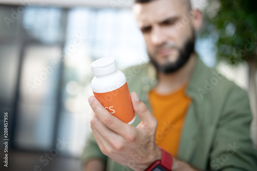 Man holding sleeping pills while suffering from insomnia