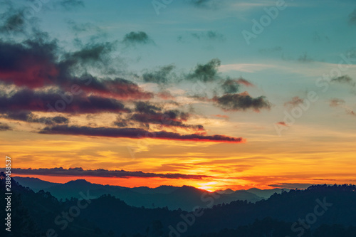 silhouette shot image of mountain and sunset sky in background. © adekub