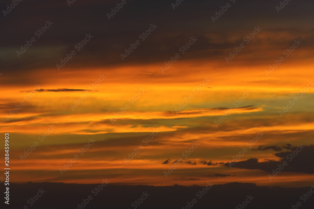 Abstract nature background. Dramatic sunset sky in the clouds saturated with bright colors of orange and yellow. Contrast Low Key Abstract nature background. Dramatic sunset sky in the clouds saturated with bright colors of orange and yellow. Contrast Low Key