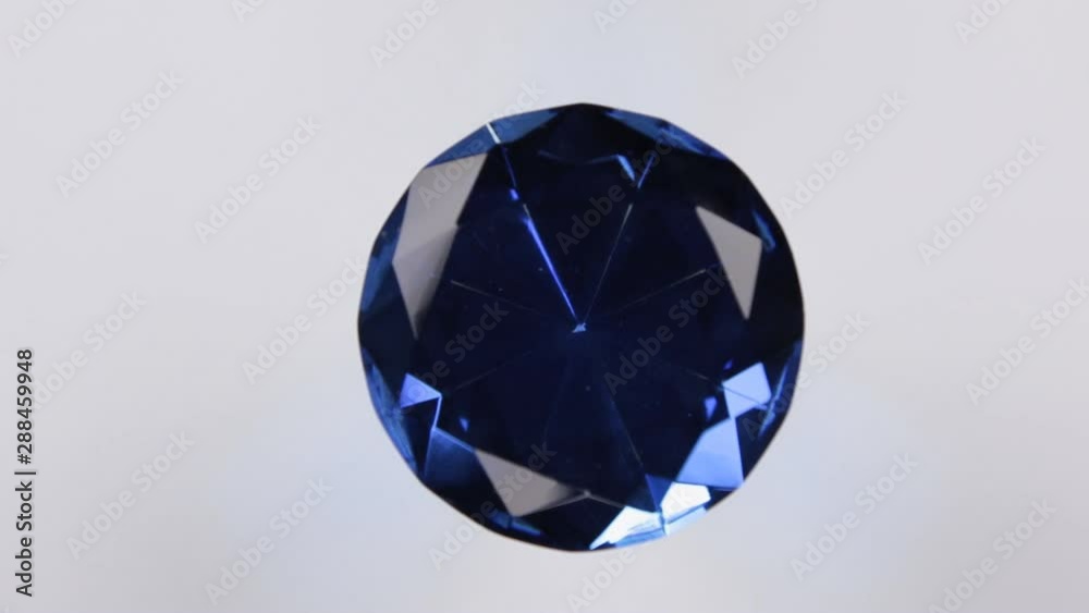 Rotation of a large blue rhinestone on a white background. With space for design, text place.
