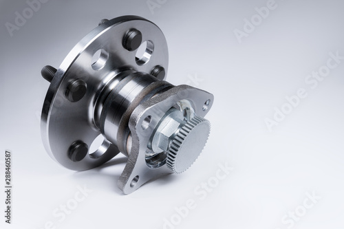 New Wheel hub assembly with bearing. This is part of the car suspension on a gray background with a gradient. The concept of new car parts