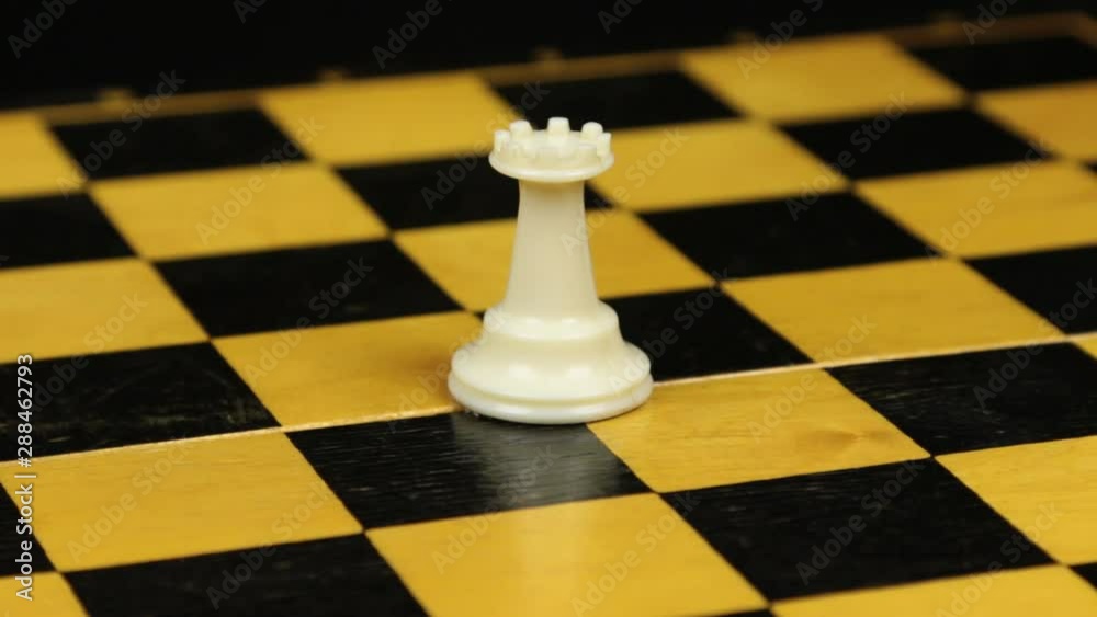Rotation. Chess figure white rook on chess board. Close-up