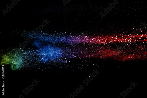 Colorful background of pastel powder explosion. Rainbow color dust splash on black background.
