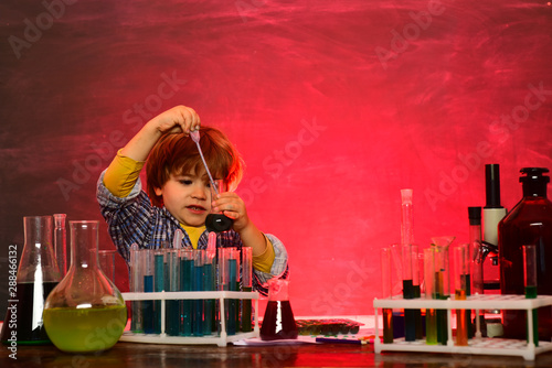 Little kids scientist earning chemistry in school lab. Science. Happy little scientist making experiment with test tube. schoolchild