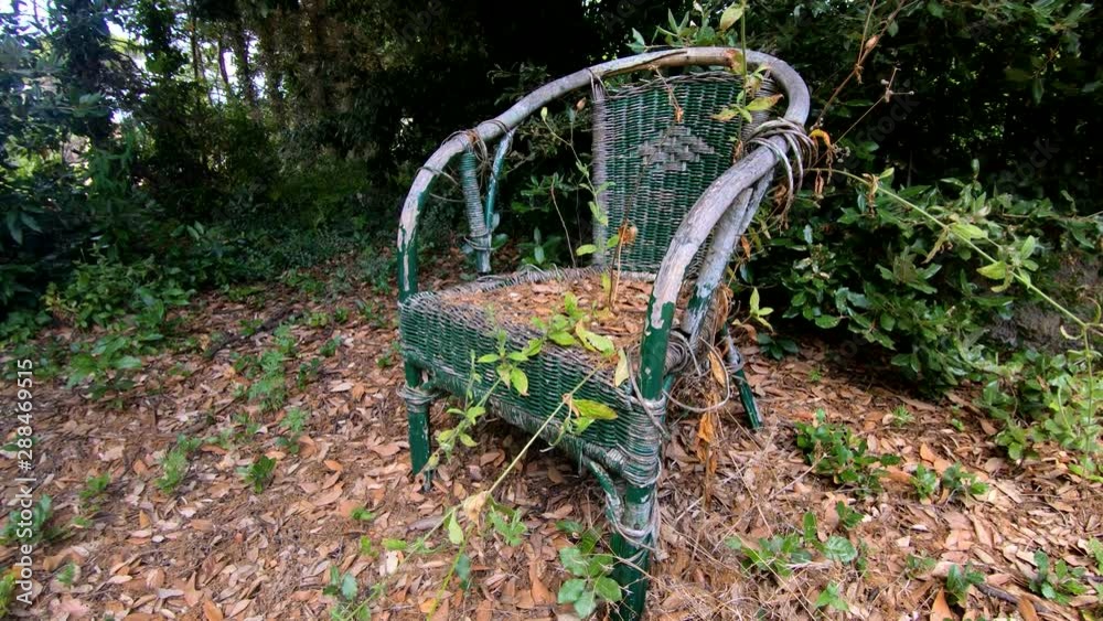 4K Left side moving right pan abandoned plastic chair in woods on bright summer day 4K Left side moving right pan abandoned plastic chair in woods on bright summer day
