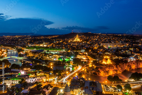 Night lights of Tbilisi, capital of Georgia, photographed from vantage point of Narikala fortress. Both banks of Kura river flowing through central part of the city are well seen.