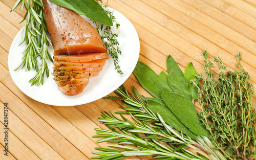 Sirloin meat with fresh rosemary, sage and thyme on a wooden table.  View from above. photo