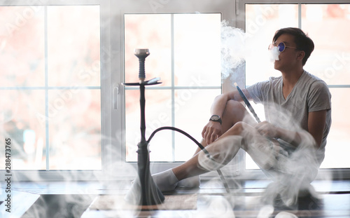 Man in sunglasses smoking a hookah