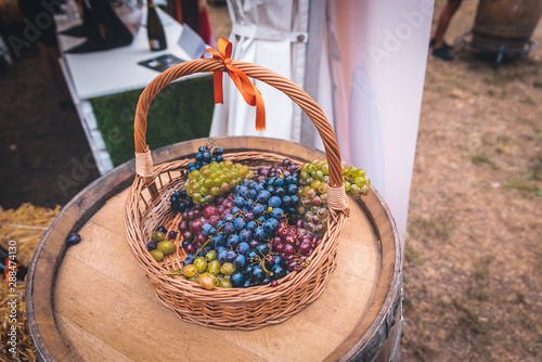 Wooden basket with yellow and black grapes