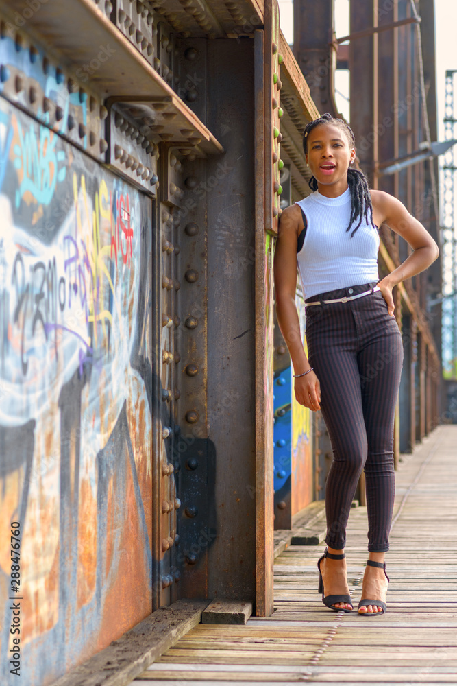 Naklejka premium Relaxed young woman leaning on an old bridge