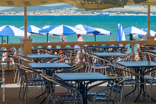 Umbrellas and cafe tables line the Gelendzhik promenade facing the bay.