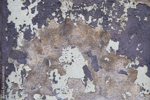 The old wall of building, covered with cracks, with peeling paint, crumbling with age. Old cement surface background. photo