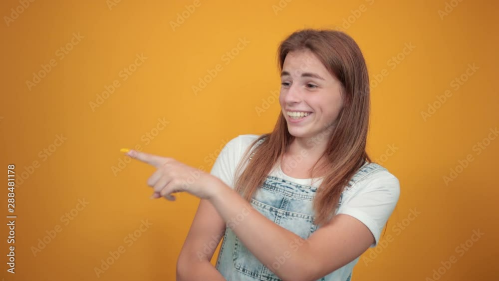 Young woman wearing white t-shirt, over orange background shows emotions Young woman wearing white t-shirt, over orange background shows emotions