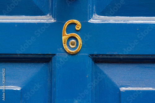 Bright blue front door with the number 6