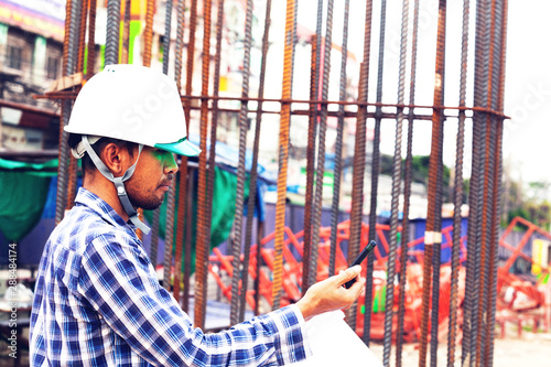 construction supervisor engineers check the project work and use the radio to coordinate with foreman to plan the work