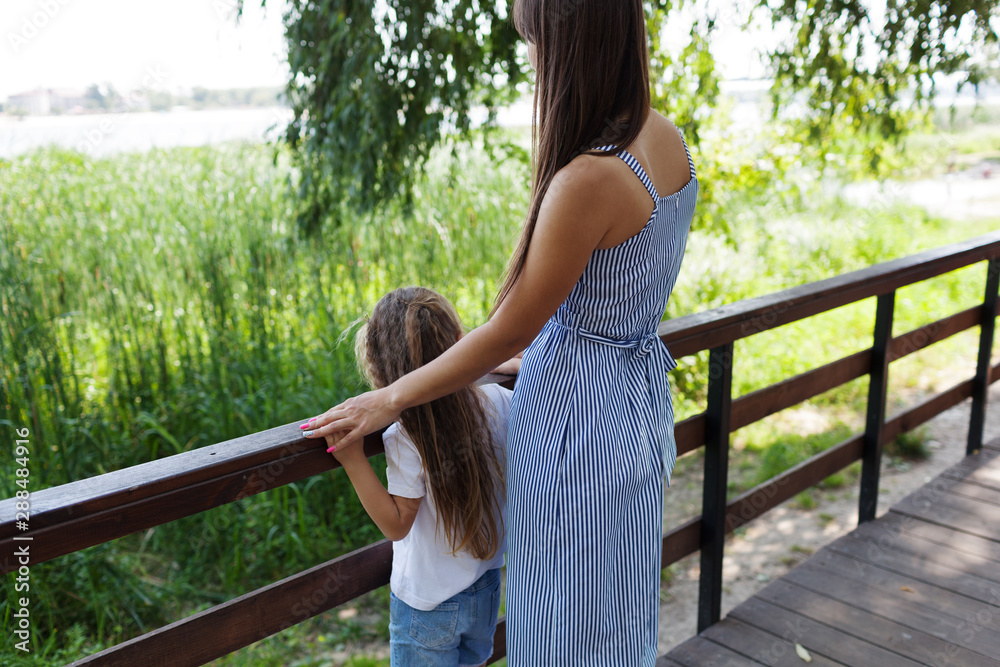Naklejka premium Mother and daughter in park. Concept of summer,childhood and leisure