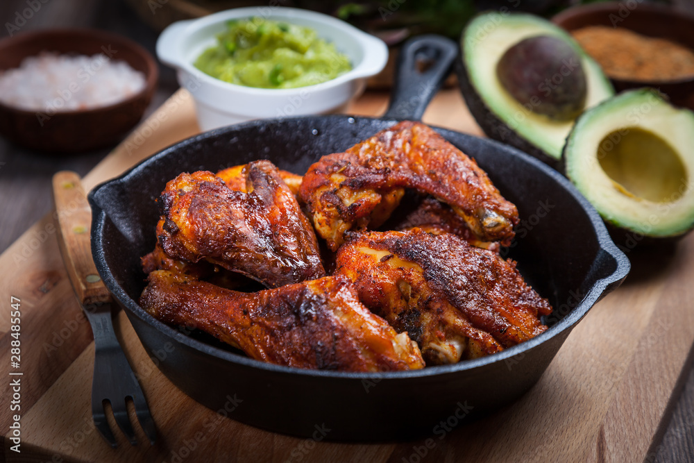 Fototapeta premium Grilled hot and spicy chicken wings with guacamole