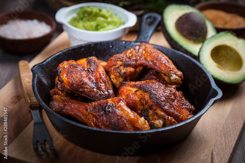 Grilled hot and spicy chicken wings with guacamole