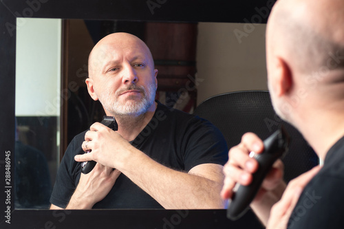 A man shaves his face. Mach...