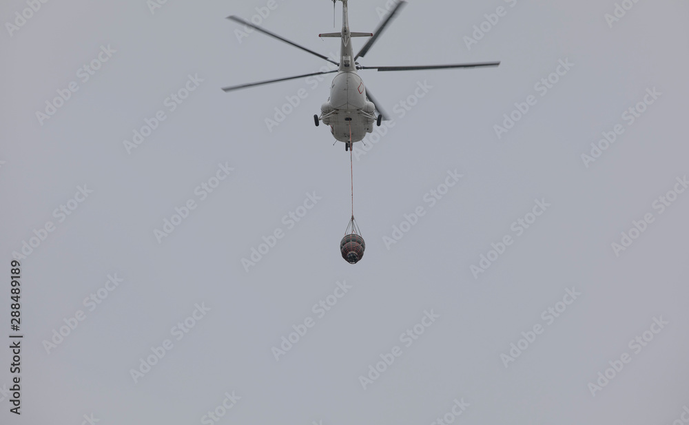 helicopter extinguishes a fire from a basket of water helicopter extinguishes a fire from a basket of water