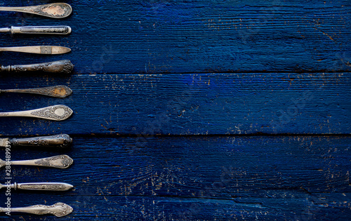 Vintage cutlery - spoons, forks and knives on an old wooden background.
