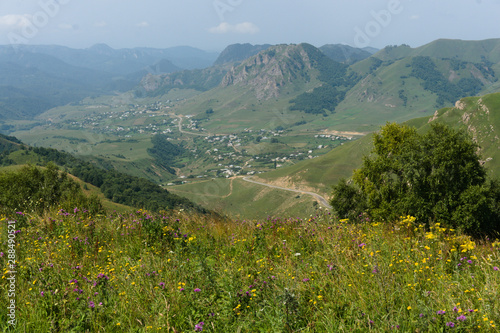 Village in the caucasus mountains, green landscape near mount elbrus at the gumbashi pass photo