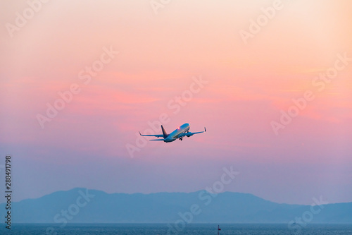 夕焼け空へ飛び立つ旅客機