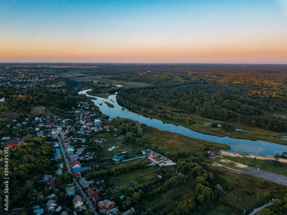 Summer rural landscape, aerial view. Village, forest and river from drone flight