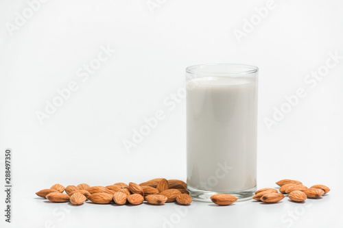 Milk with almonds nut on white background.
