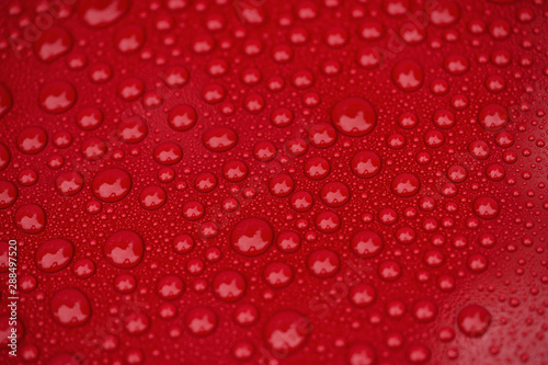 Closeup red car paint surface with hydrophobic ceramic coating