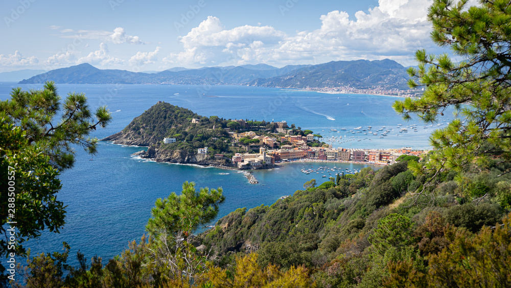 Sestri Ponente, Genoa, Italy. Baia del Silenzio panoramic view from above immersed in nature. In the background Ligurian mountains topped by white clouds