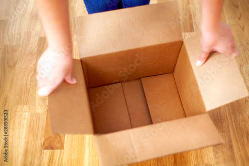 Woman hands opens cardboard box.