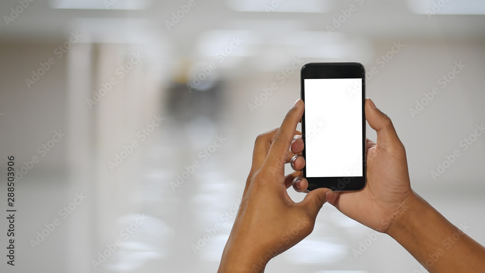 man's hands holding mockup mobile phone in room. man's hands holding mockup mobile phone in room.
