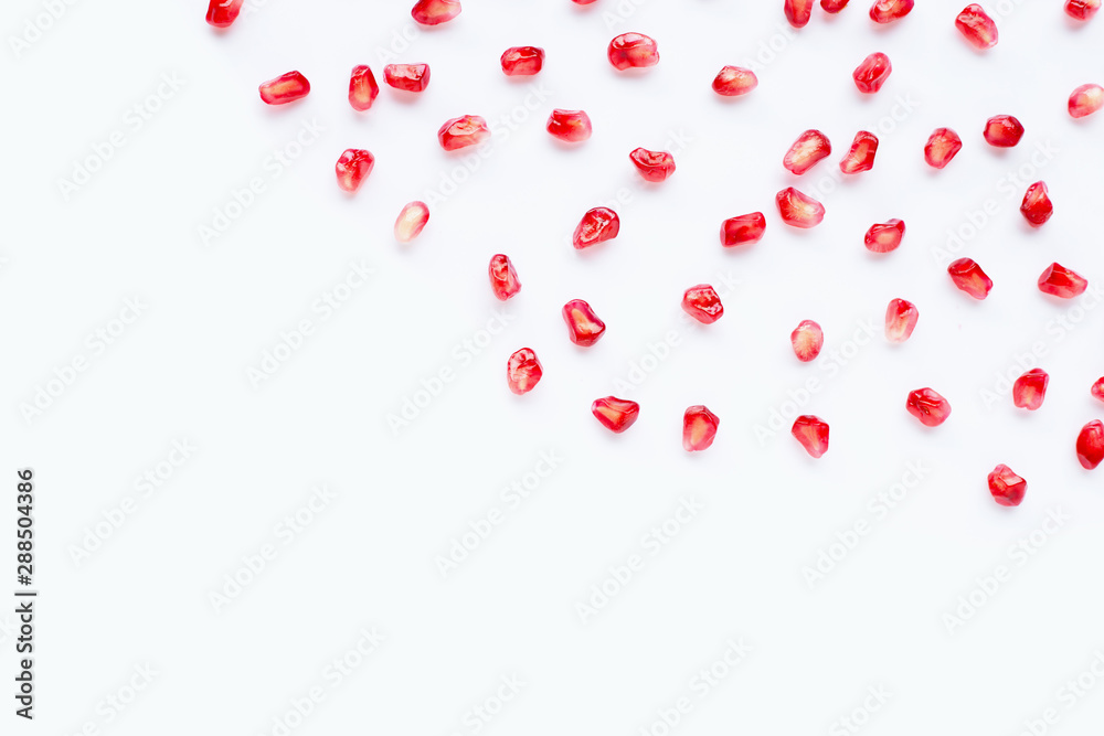 Pomegranate seeds on white. Copy space