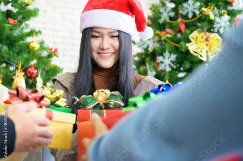 Asian people party celebrate christmas and new year eve in house. Man and woman giving gift box together