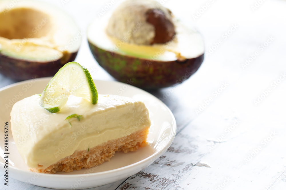 Home made avocado lime cheesecake on a white wood background