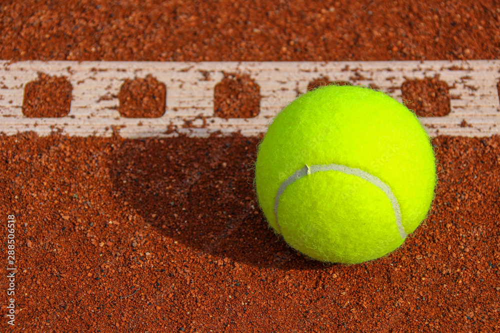 One tennis ball on tennis court with a line