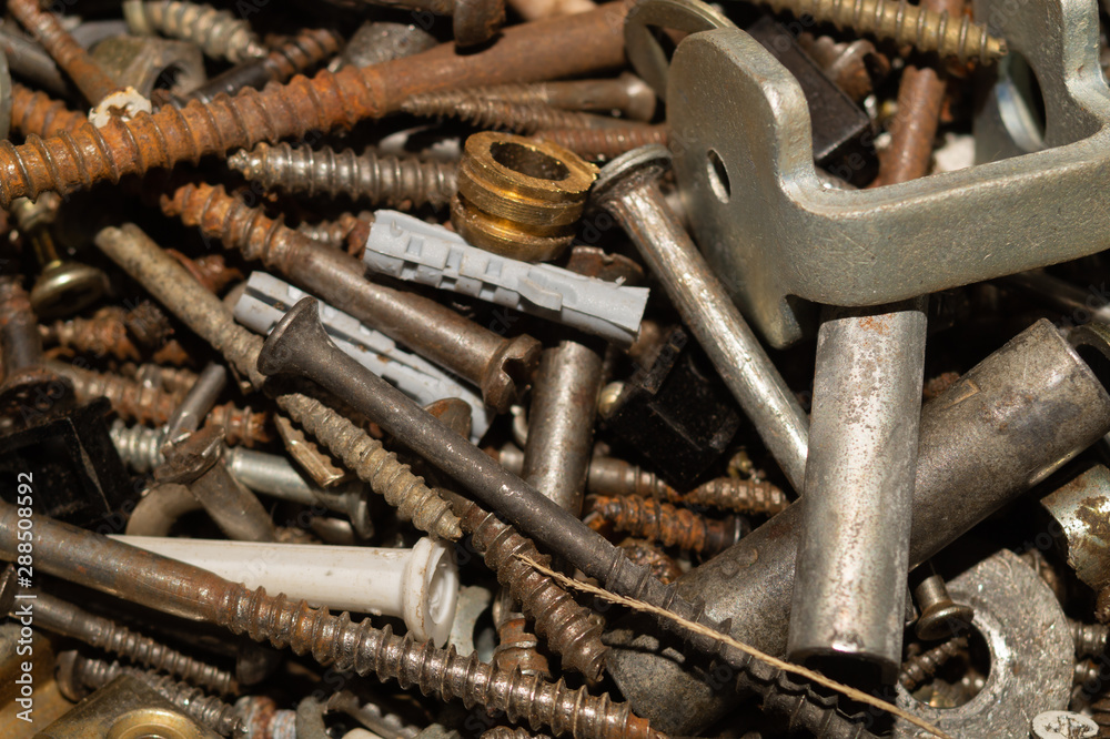Screws background. heap of tapping screws. work tool. pile of fasteners. bolts and nuts. metal scrape Screws background. heap of tapping screws. work tool. pile of fasteners. bolts and nuts. metal scrape