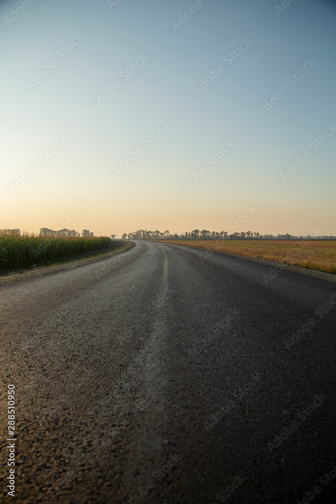 New asphalt road at golden sunset